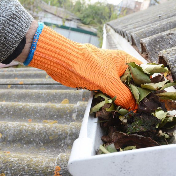 person-cleaning-out-roof-gutter-a7d758c873274953bd00f9dfd35b665d